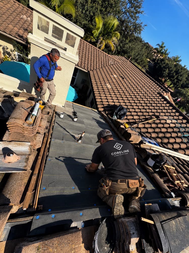 Coreline crew laying underlayment on a tile roof